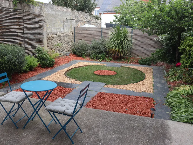 Garden table and chairs on the shaded terrace, opening onto the shared garden